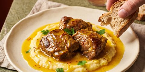 Plato hondo con carrilladas de cerdo guisadas en salsa dorada de vino blanco con hebras de azafrán Antonio Sotos y un toque de perejil fresco.