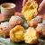 Buñuelos de viento dorados espolvoreados con azúcar glas, rellenos de crema pastelera de azafrán Antonio Sotos y chocolate blanco.